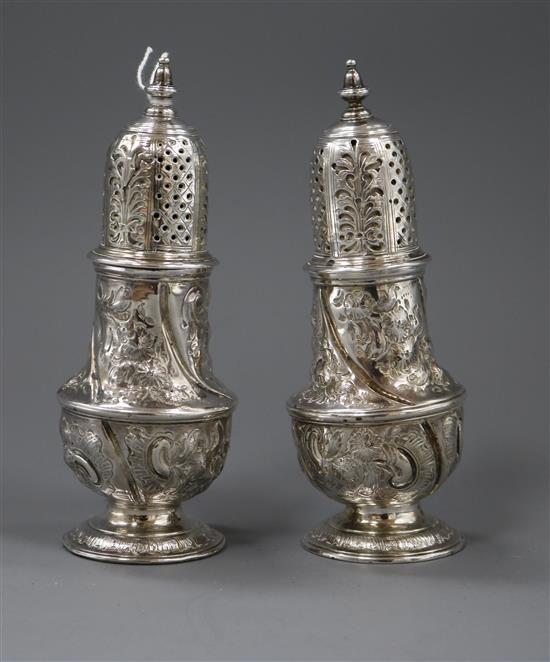 A pair of George II silver pepperettes, with later embossed decoration, Samuel Wood, London, 1748, 14cm.